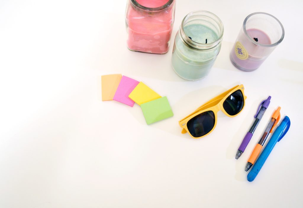 post-it notes glasses pens and candles